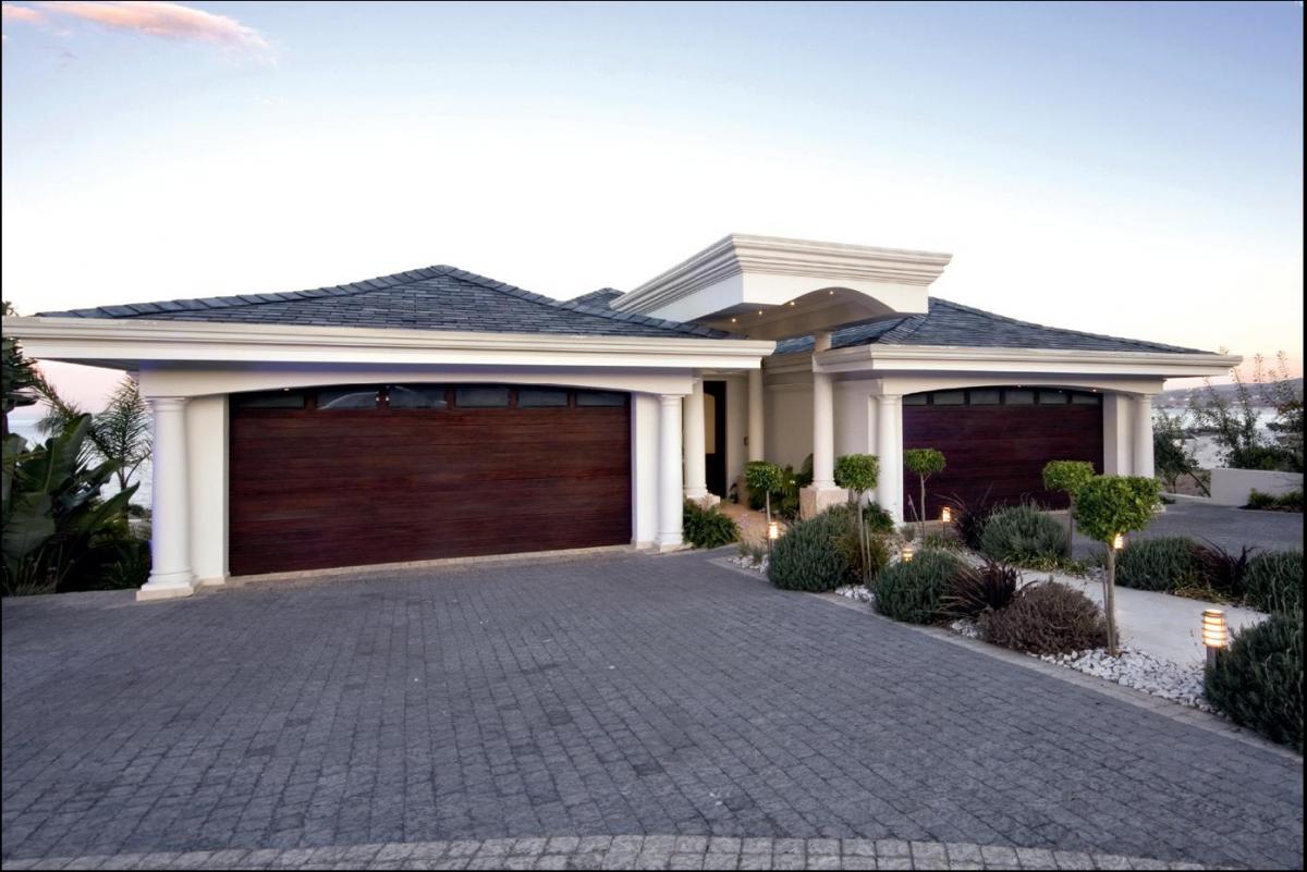 Coroma (0860 42 72 43)These automated sectional overhead Coroma garage doors were customdesigned by Trellicor West Coast to accommodate glass panels that echo the lintel’s curve. The owners chose Coroma’s Corowood design, which complements the frontdoor. Coroma manufactures designs in timber, aluminium and steel to enhance the facade of any home style.