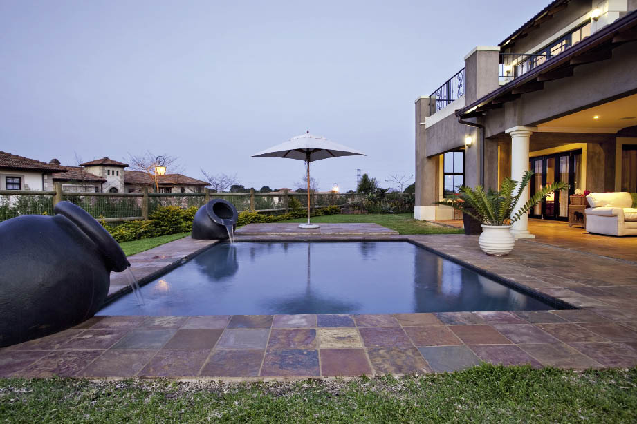 Sunshine Pools designed ( 031 307 4318 )and constructed the custom-made pool to the clients’ specifications. A light grey was mixed into the plaster to avoid the conventional white plaster, giving the water a relaxed blue look, as well as reducing the appearance of dirt marks. Two oversized pots were placed on opposite ends drawing the eye outwards into the garden.